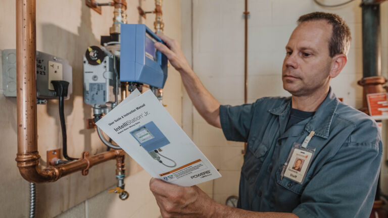 Employee installing the IntelliStation Jr. device with the installation instructions